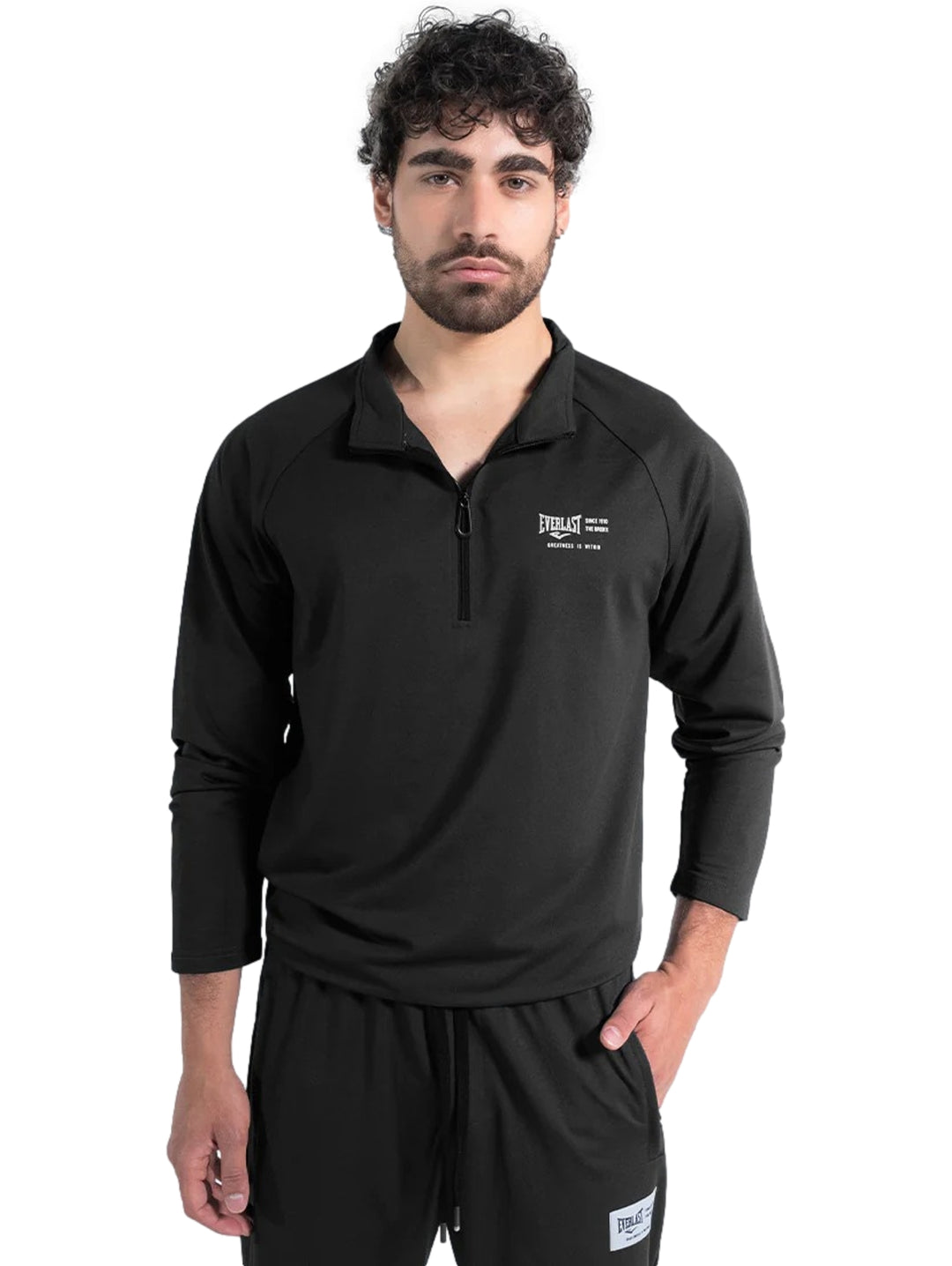 Hombre vistiendo chamarra deportiva negra de manga larga con cierre parcial de la marca Everlast.