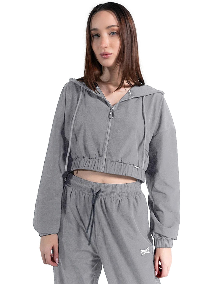 Mujer vistiendo conjunto deportivo gris de Everlast compuesto por chamarra corta con capucha y pantalón