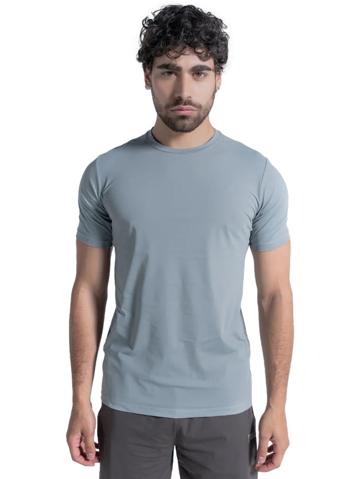 Hombre vistiendo playera deportiva de color gris claro de manga corta y cuello redondo.