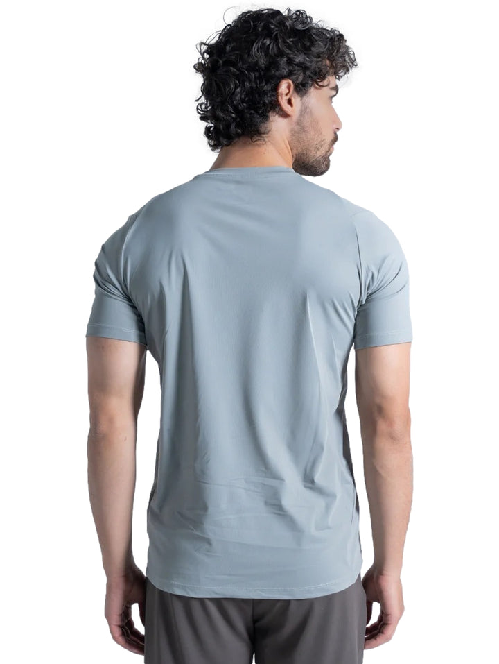 Hombre vistiendo playera deportiva de color gris claro de manga corta y cuello redondo.
