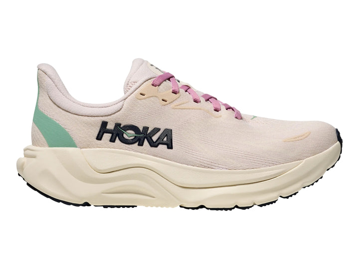Tenis deportivos HOKA Arahi 8 en color rosa crema y blanco hueso con suela ancha y amortiguada.