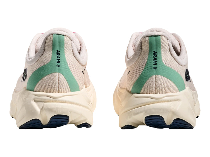 Tenis deportivos HOKA Arahi 8 en color rosa crema y blanco hueso con suela ancha y amortiguada.