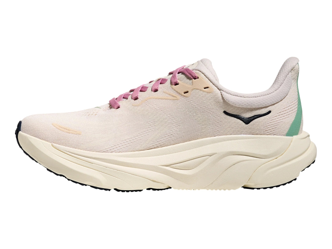 Tenis deportivos HOKA Arahi 8 en color rosa crema y blanco hueso con suela ancha y amortiguada.