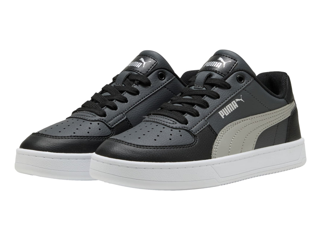 Tenis PUMA Caven 2.0 JR color negro con franja gris y suela blanca, vista lateral.