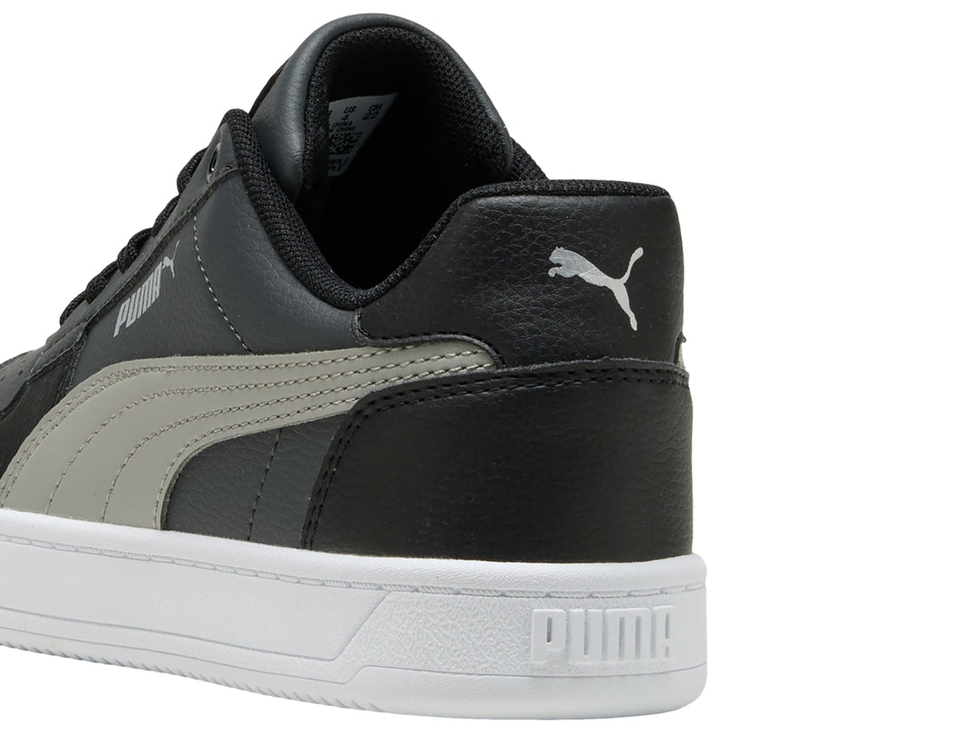 Tenis PUMA Caven 2.0 JR color negro con franja gris y suela blanca, vista lateral.