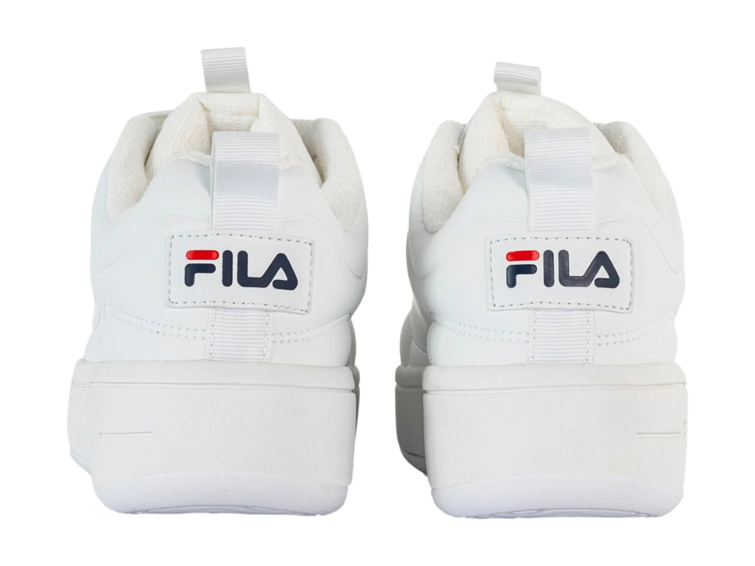 Tenis FILA blancos de plataforma con suela gruesa y cordones blancos.