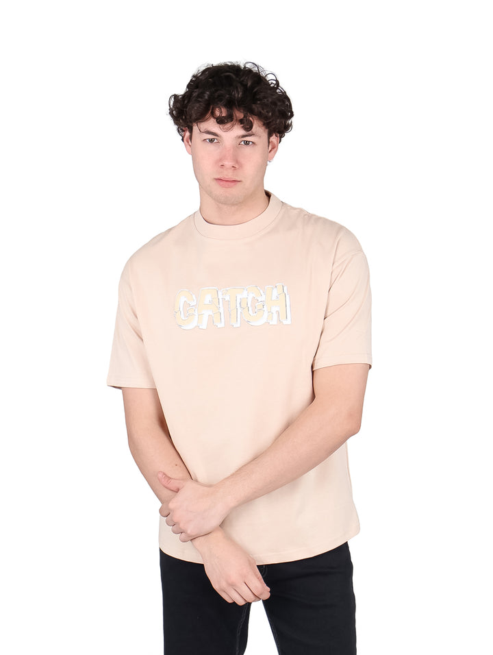 Hombre vistiendo playera oversize color beige con estampado frontal &
