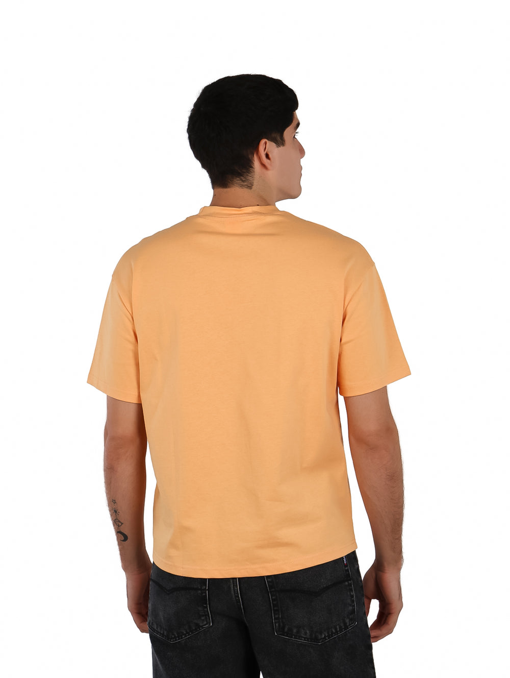Hombre vistiendo playera oversize color anaranjado con estampado gráfico en el pecho.