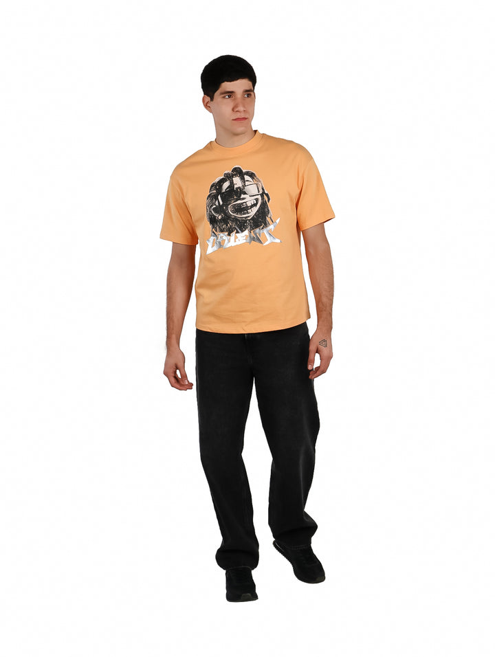 Hombre vistiendo playera oversize color anaranjado con estampado gráfico en el pecho.