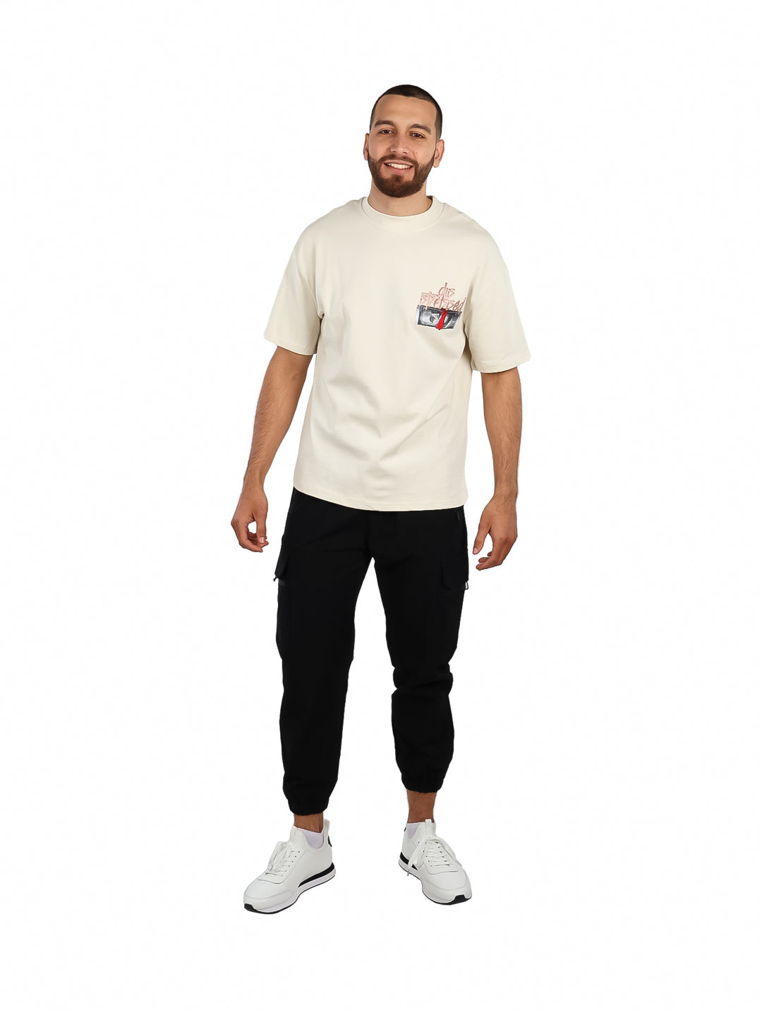 Hombre vistiendo una playera oversize de color beige con un pequeño gráfico en el pecho.