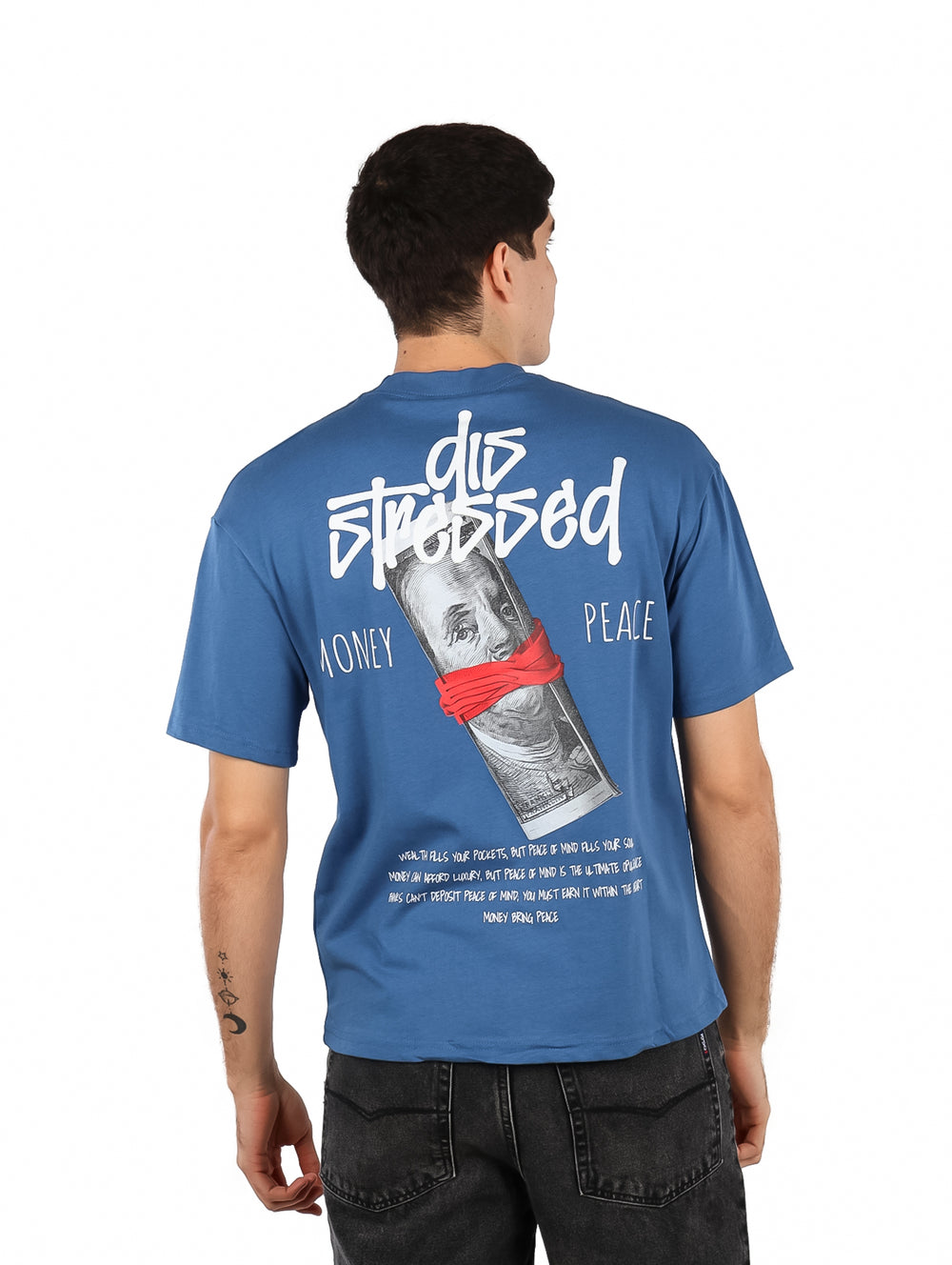 Hombre vistiendo playera azul oversize de manga corta con estampado gráfico en el pecho.