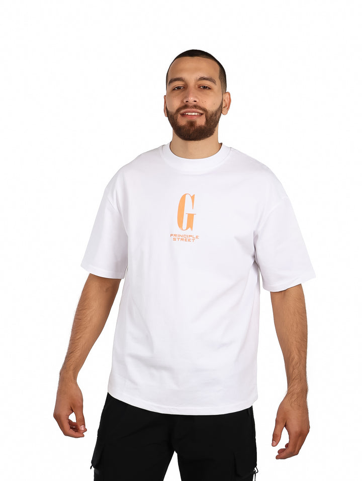 Hombre vistiendo playera blanca oversize de manga corta con un gráfico naranja en el pecho.
