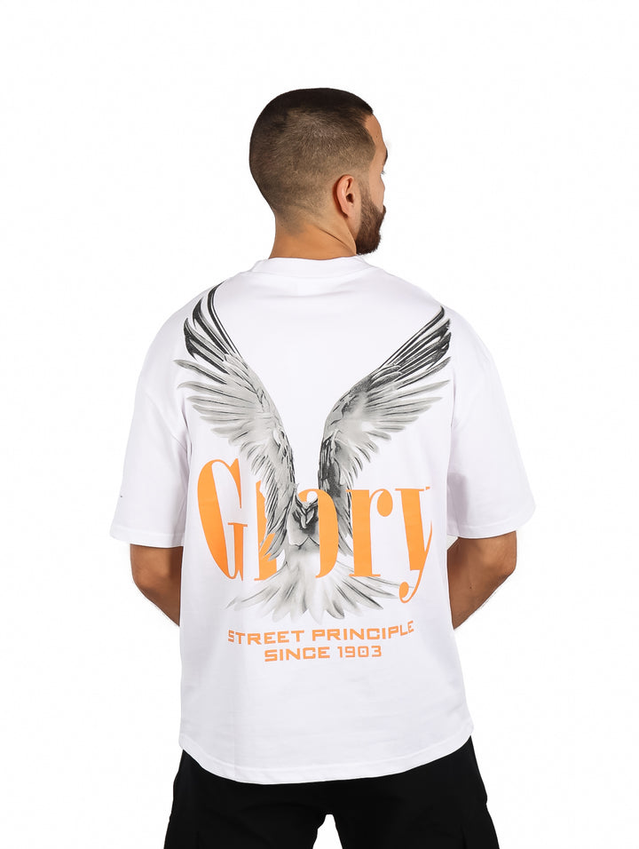 Hombre vistiendo playera blanca oversize de manga corta con un gráfico naranja en el pecho.