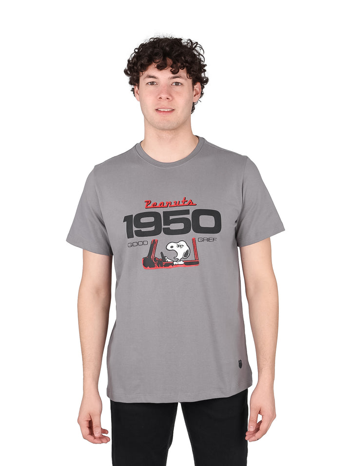 Hombre vistiendo playera gris de manga corta con estampado de Peanuts y Snoopy en el pecho.