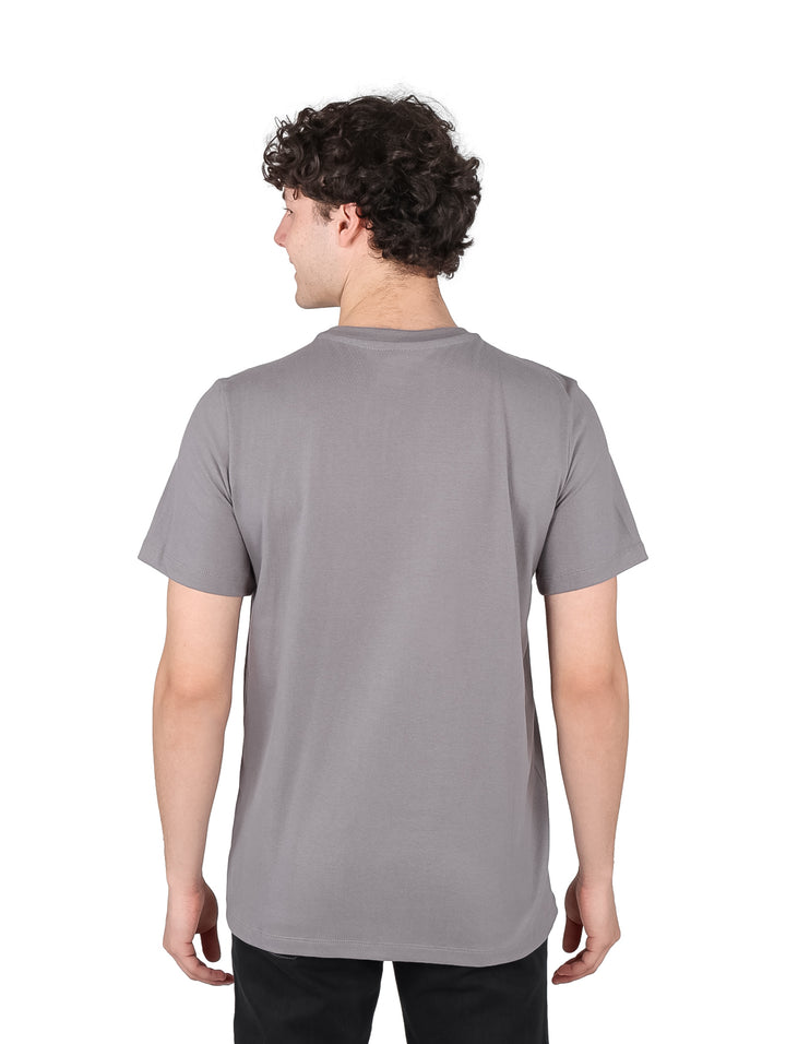 Hombre vistiendo playera gris de manga corta con estampado de Peanuts y Snoopy en el pecho.