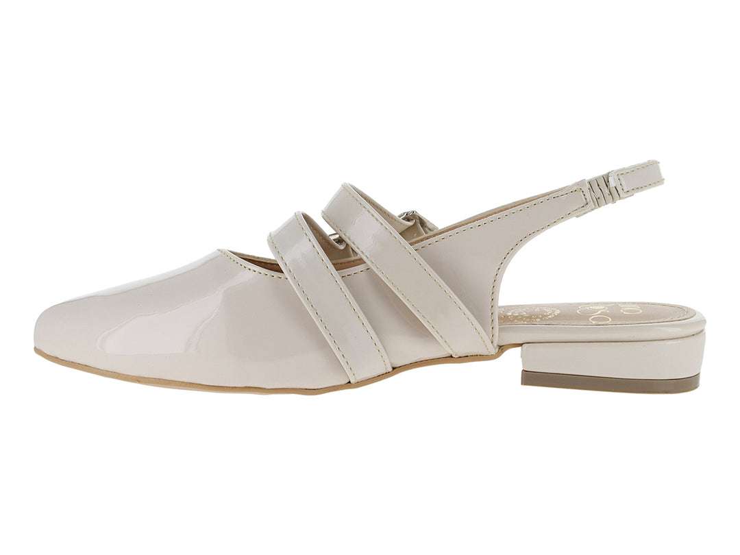 Zapato plano color beige de charol brillante con dos hebillas y correa trasera.
