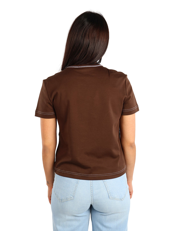 Mujer vistiendo una camiseta ajustada color café de Calvin Klein con costuras blancas contrastantes.