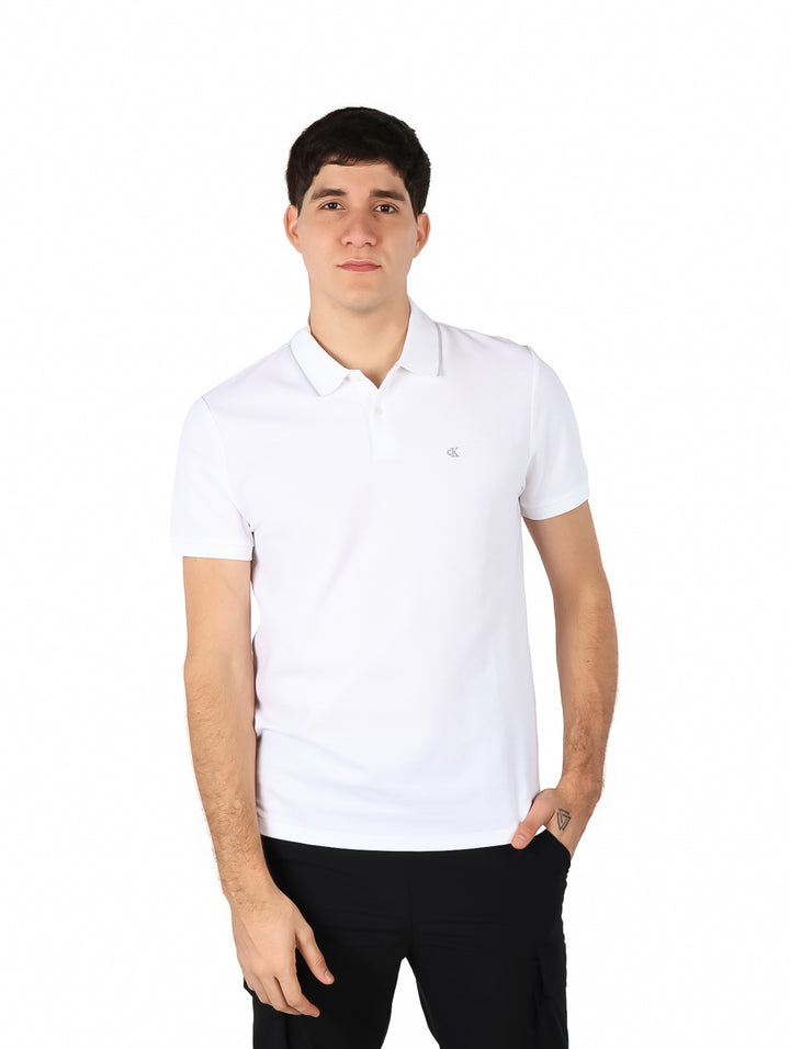 Hombre vistiendo una playera polo blanca de manga corta de la marca Calvin Klein.