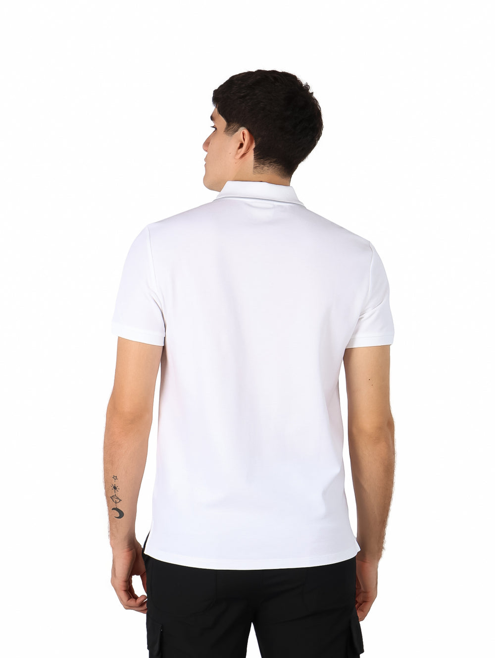 Hombre vistiendo una playera polo blanca de manga corta de la marca Calvin Klein.