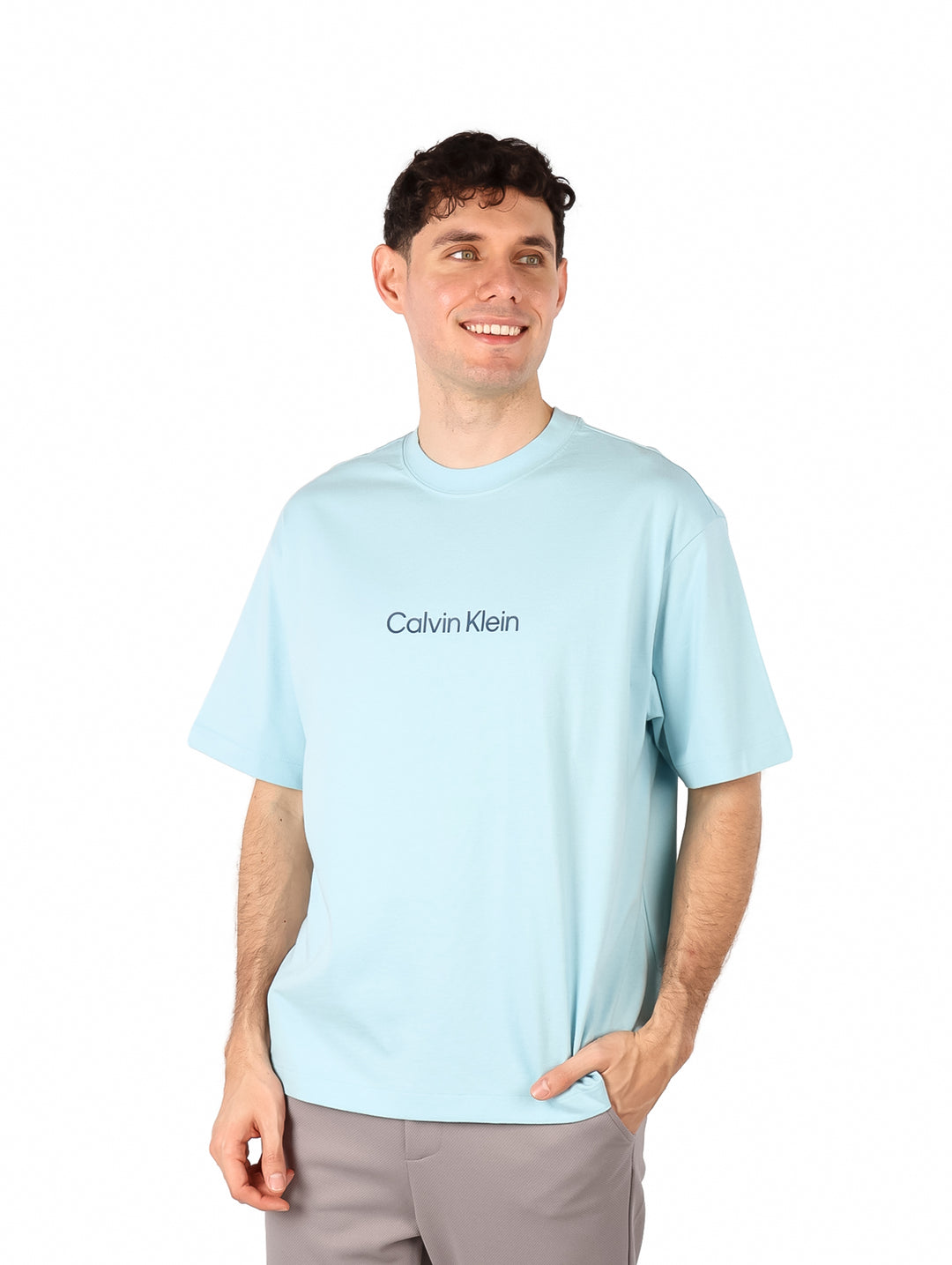 Hombre vistiendo una camiseta de manga corta color azul claro con el logo de Calvin Klein en el pecho.