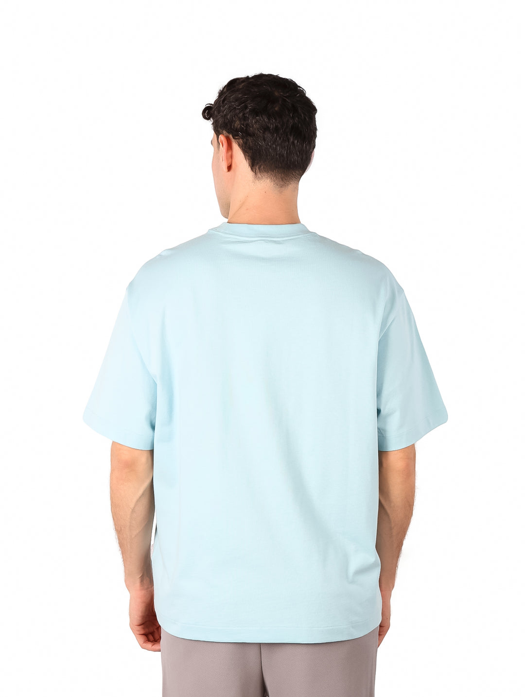 Hombre vistiendo una camiseta de manga corta color azul claro con el logo de Calvin Klein en el pecho.