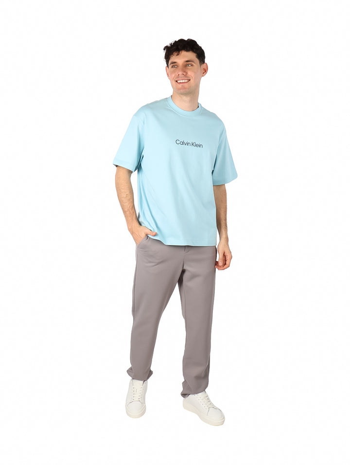 Hombre vistiendo una camiseta de manga corta color azul claro con el logo de Calvin Klein en el pecho.