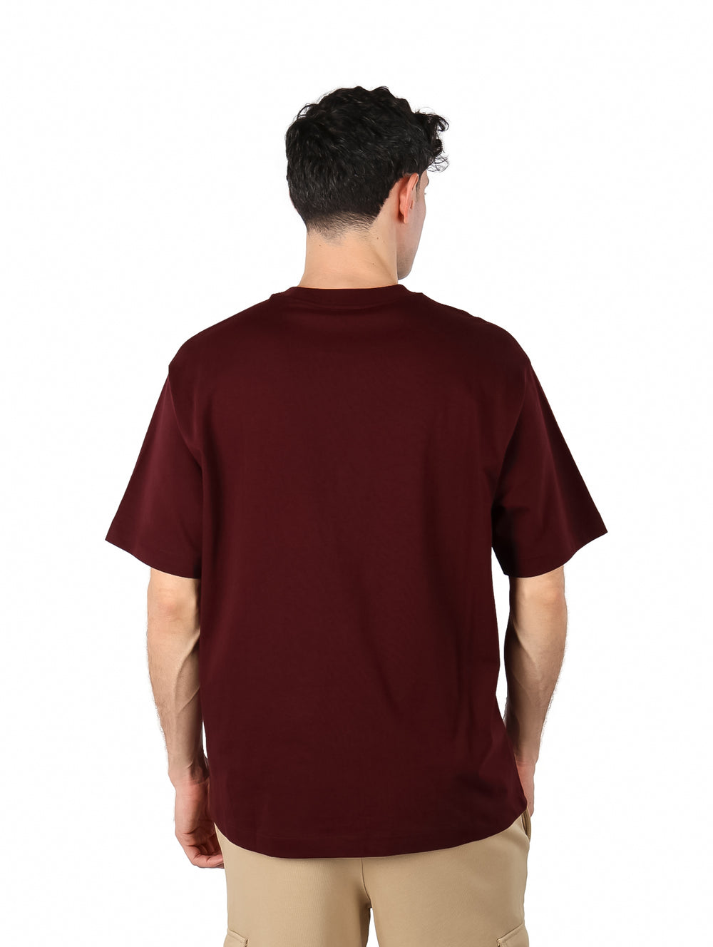 Hombre vistiendo una camiseta de manga corta color marrón oscuro con el logo de Calvin Klein en el pecho.