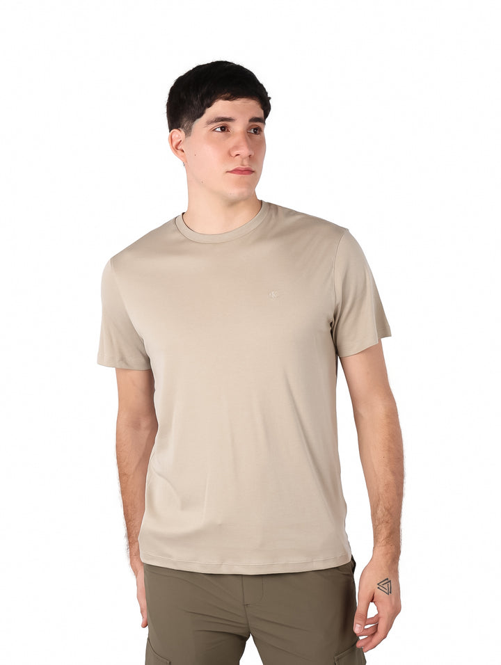 Hombre vistiendo una camiseta de manga corta color beige con cuello redondo.