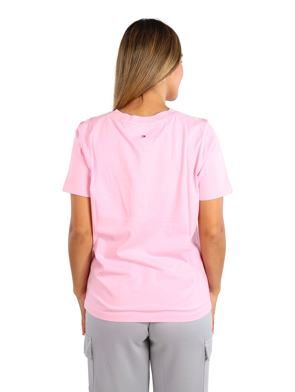 Mujer vistiendo una playera rosa de manga corta y cuello redondo.