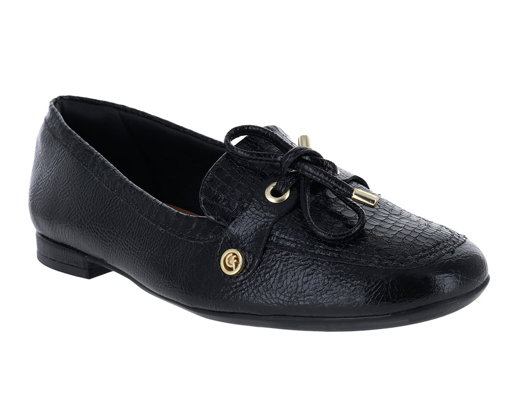 Mocasín negro para mujer con textura granulada y detalle de moño dorado en la parte superior.