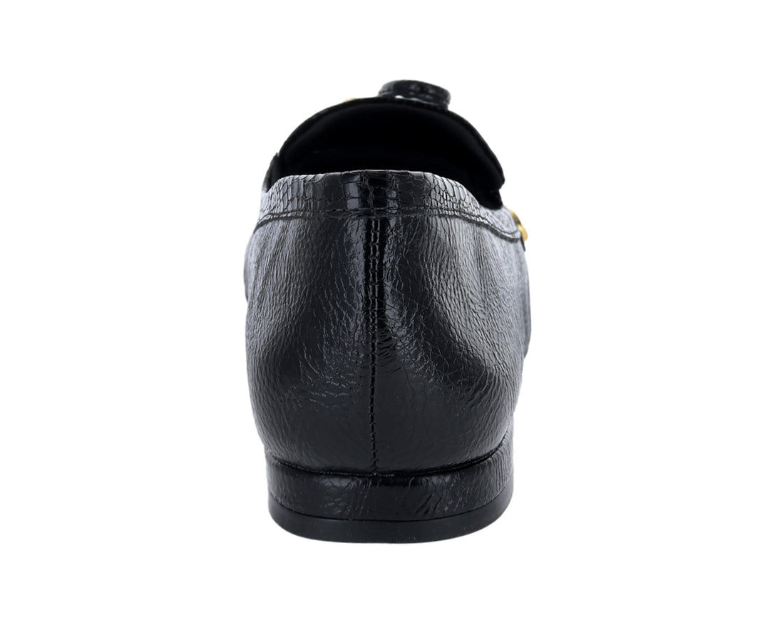 Mocasín negro para mujer con textura granulada y detalle de moño dorado en la parte superior.