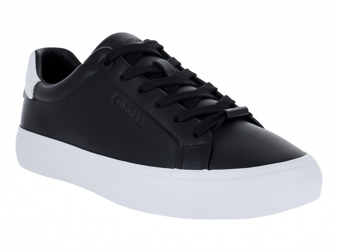 Tenis Calvin Klein de cuero color negro con suela blanca y cordones.