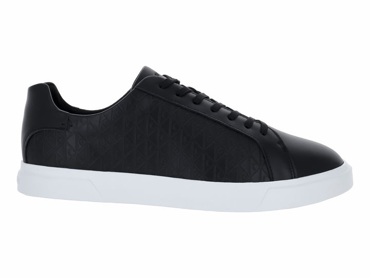 Tenis Calvin Klein de cuero negro con diseño grabado y suela blanca contrastante.