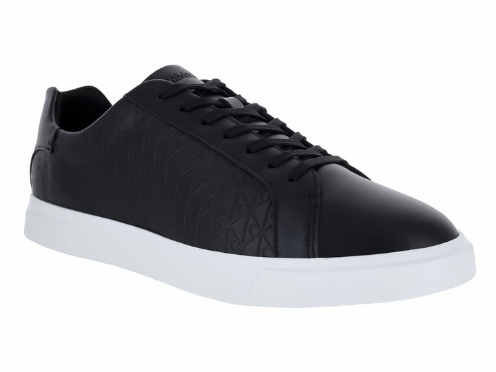 Tenis Calvin Klein de cuero negro con diseño grabado y suela blanca contrastante.