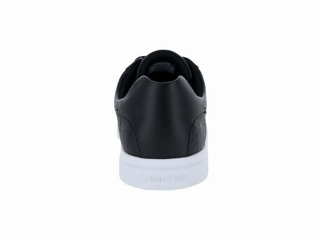 Tenis Calvin Klein de cuero negro con diseño grabado y suela blanca contrastante.