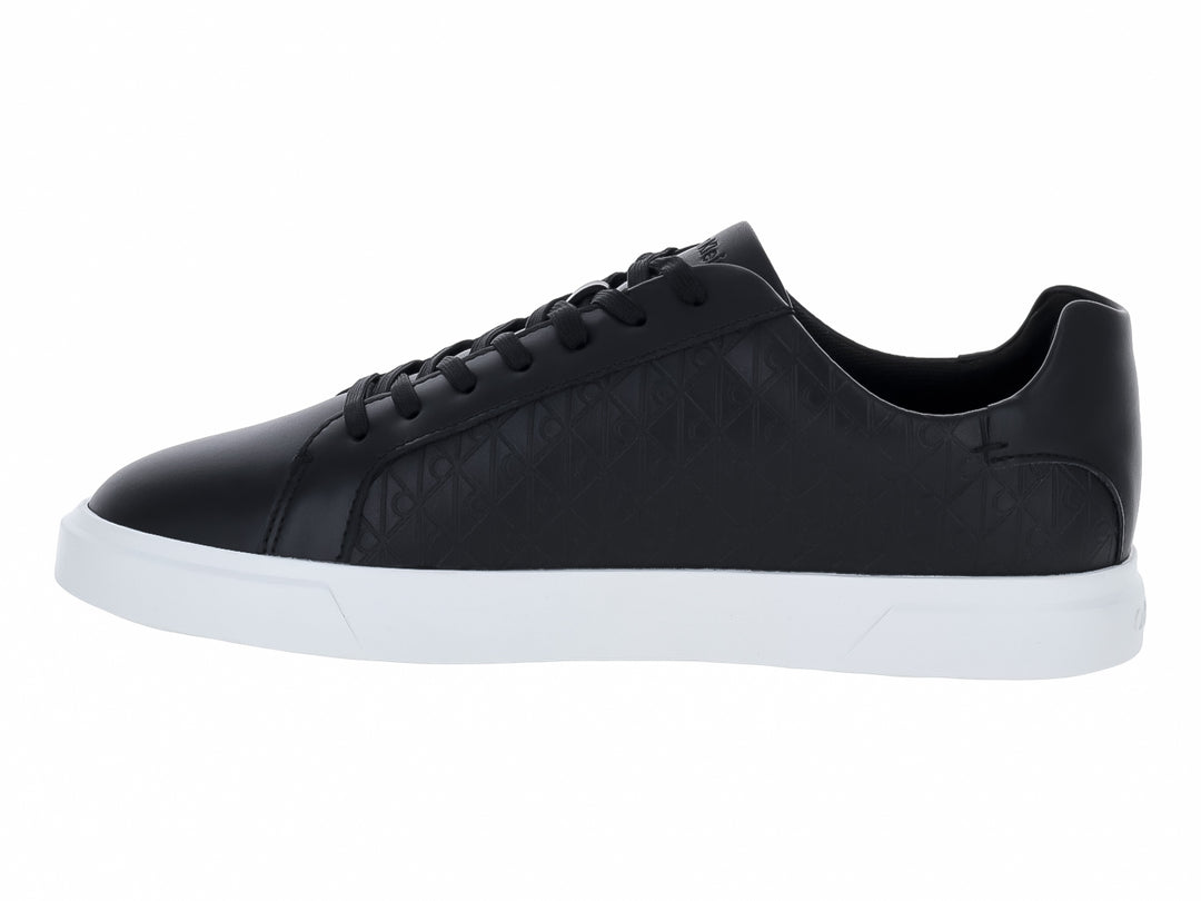 Tenis Calvin Klein de cuero negro con diseño grabado y suela blanca contrastante.