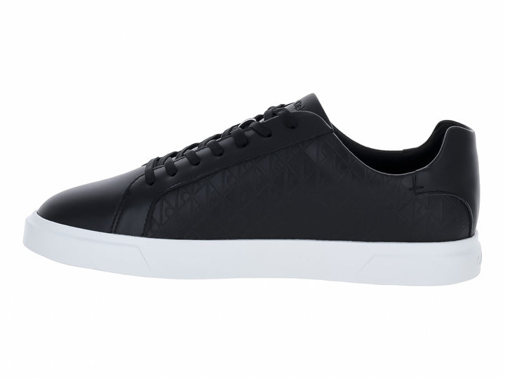Tenis Calvin Klein de cuero negro con diseño grabado y suela blanca contrastante.