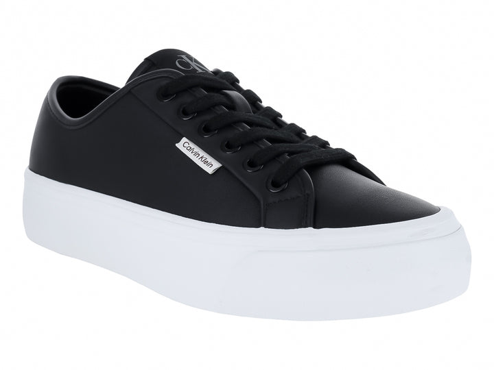 Tenis Calvin Klein de cuero negro con suela de plataforma blanca y cordones negros.