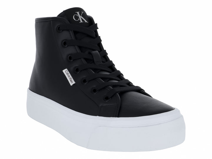 Tenis Calvin Klein de cuello alto en color negro con suela blanca ancha y plana.