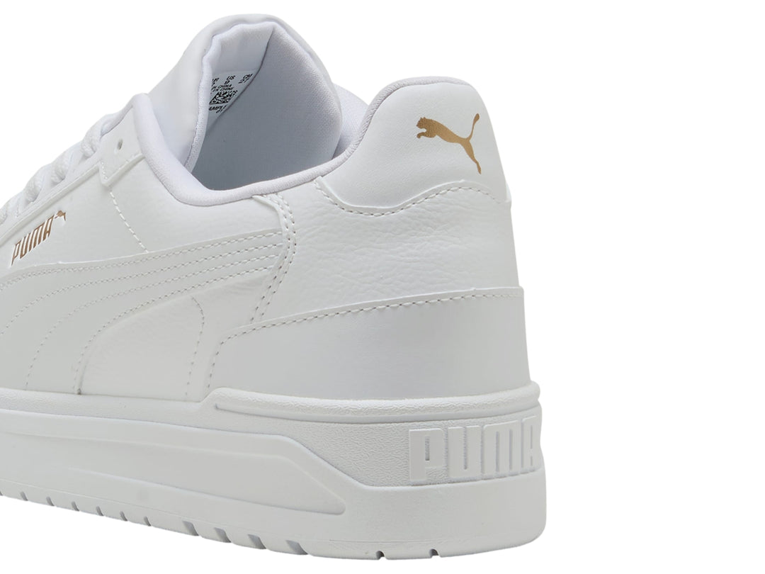 Tenis PUMA Shuffle Downtown color blanco con detalles dorados, vista lateral.
