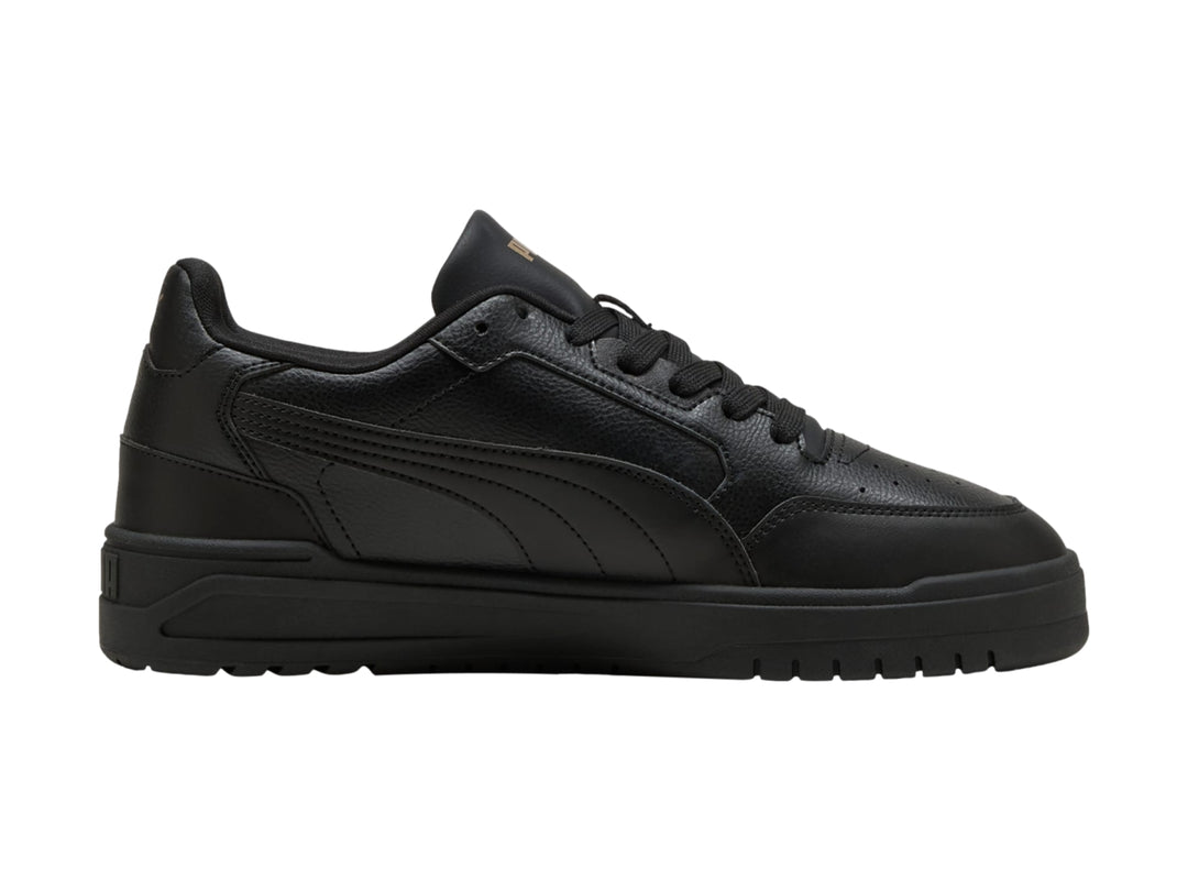 Tenis PUMA Shuffle Downtown color negro con suela gruesa y detalles dorados, vista lateral.