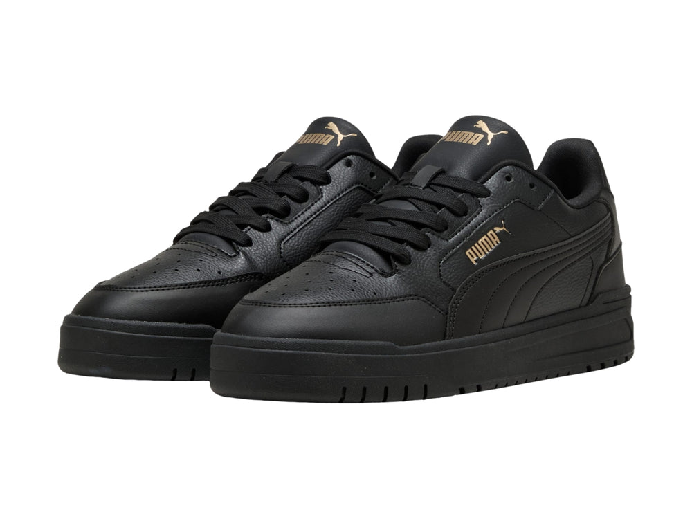 Tenis PUMA Shuffle Downtown color negro con suela gruesa y detalles dorados, vista lateral.