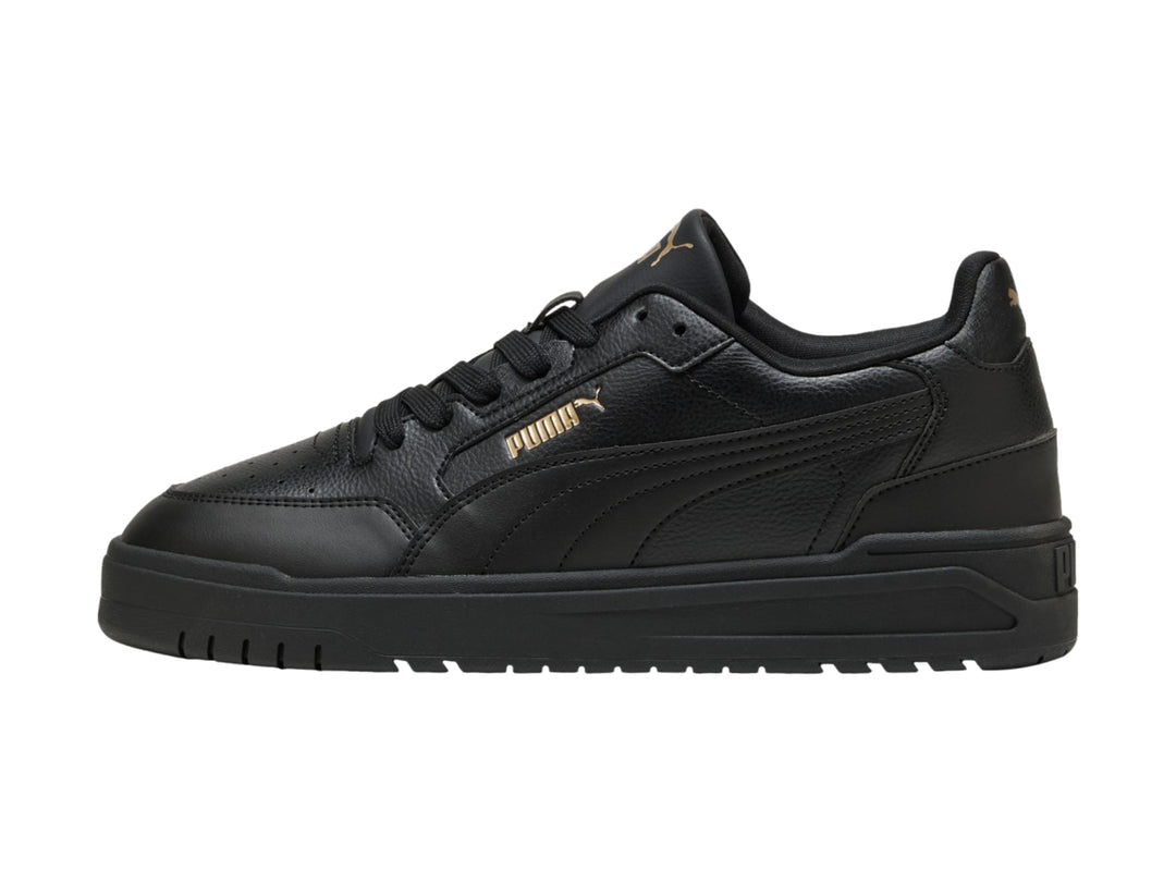 Tenis PUMA Shuffle Downtown color negro con suela gruesa y detalles dorados, vista lateral.