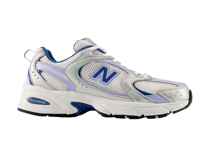 Tenis New Balance 530 para mujer en color plateado metálico y azul con detalles en malla blanca.