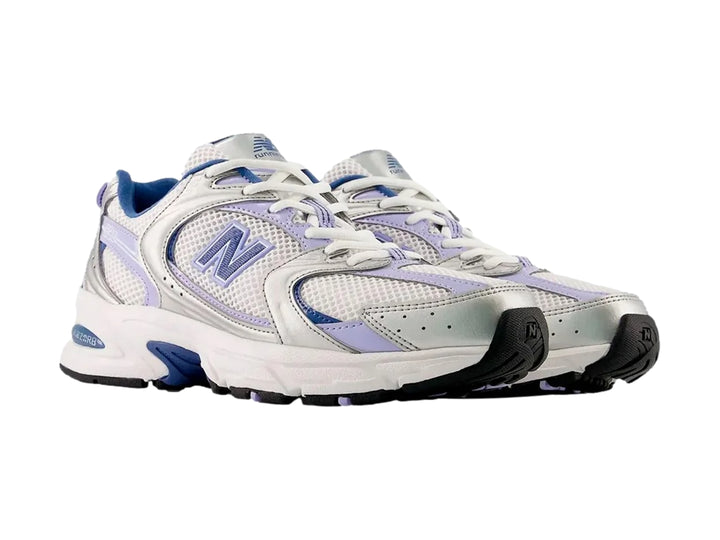 Tenis New Balance 530 para mujer en color plateado metálico y azul con detalles en malla blanca.