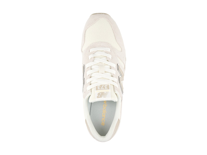 Tenis New Balance color beige con detalles en blanco y amarillo, vista lateral.