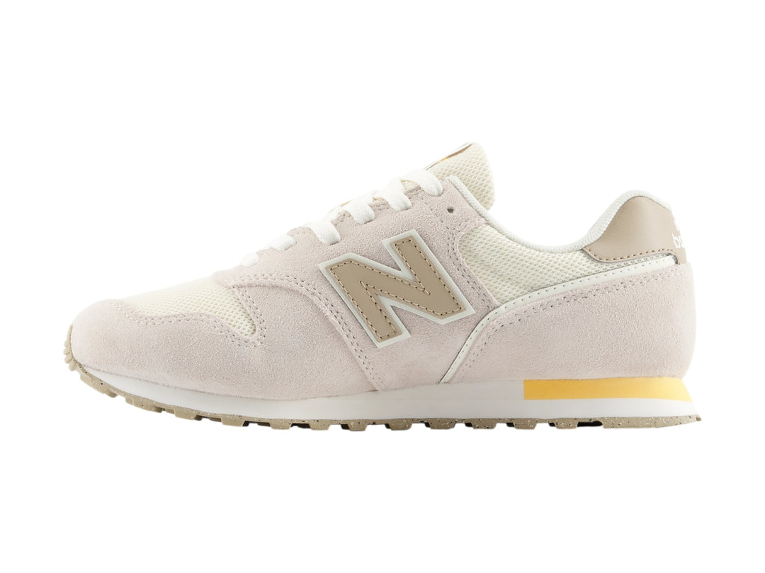 Tenis New Balance color beige con detalles en blanco y amarillo, vista lateral.