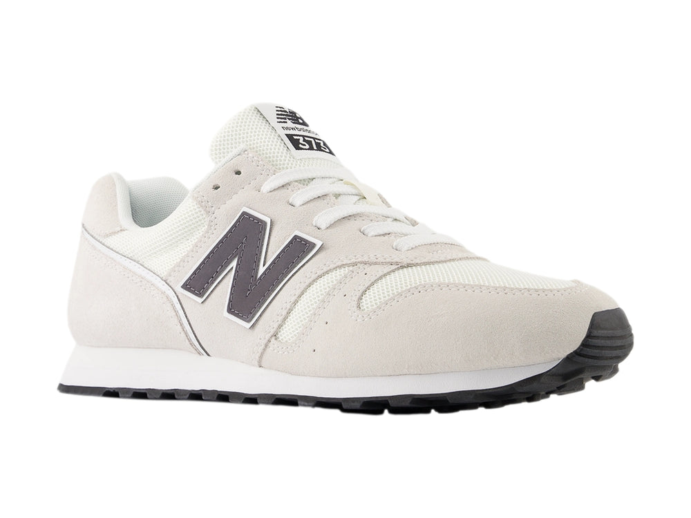 Tenis New Balance color gris con suela blanca y detalles en malla y gamuza.