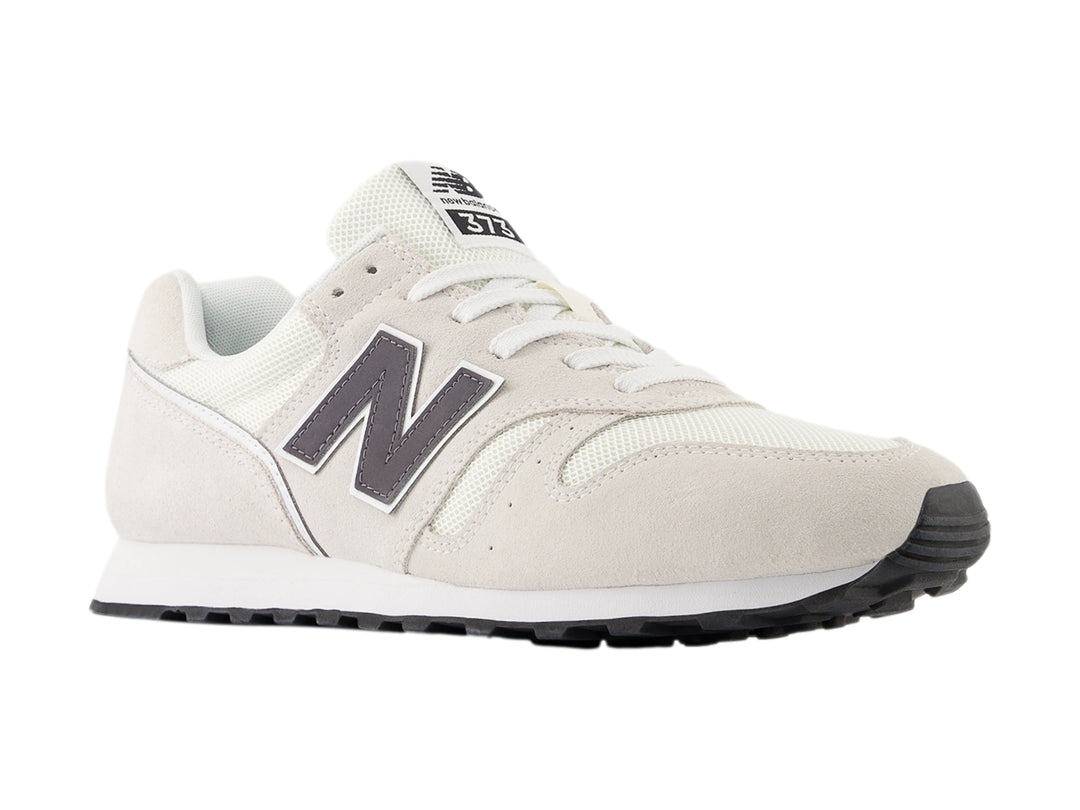 Tenis New Balance color gris con suela blanca y detalles en malla y gamuza.