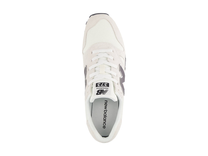 Tenis New Balance color gris con suela blanca y detalles en malla y gamuza.